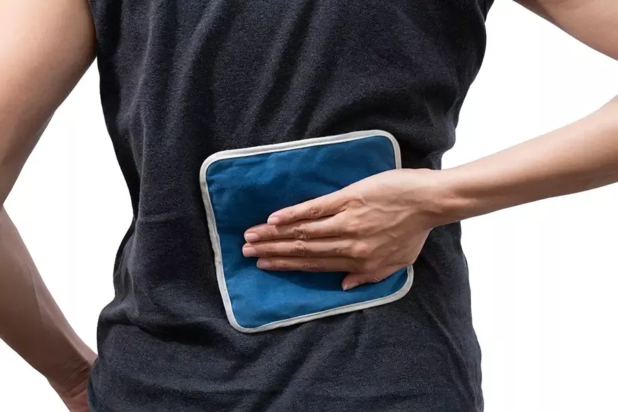 Person holding an ice pack on their lower back