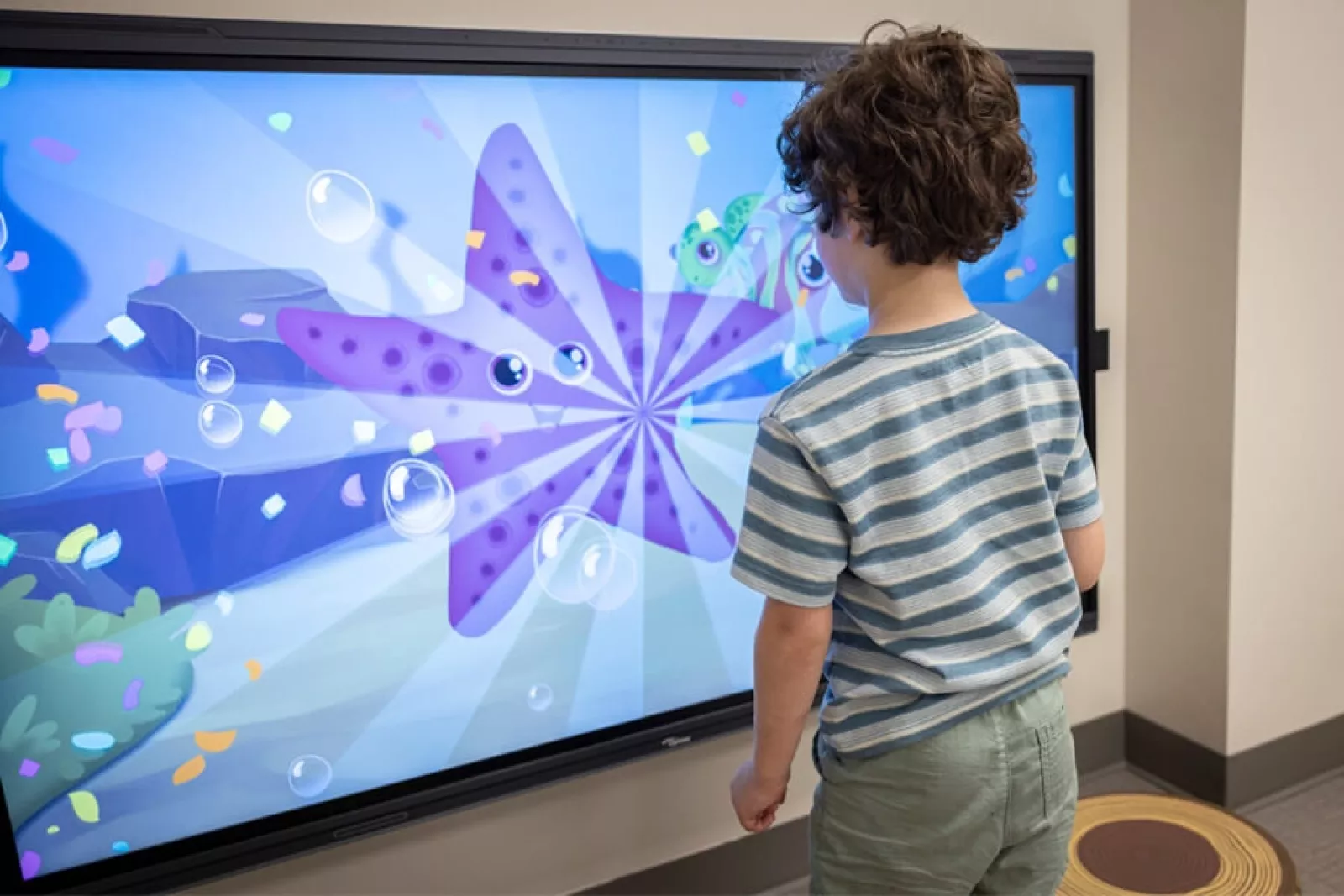 Child playing with the interactive screen in the lobby