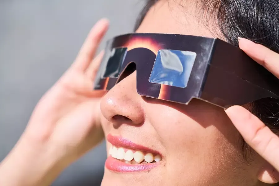Lady with solar eclipse glasses on