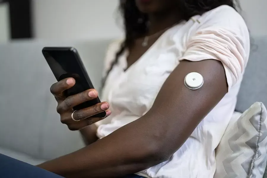 Lady with a continuous glucose monitor on her arm