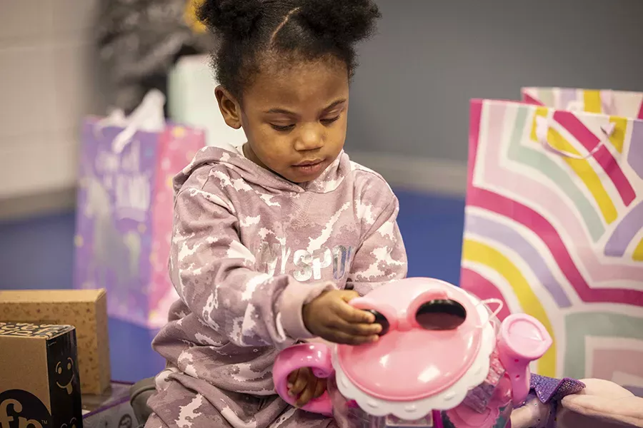 Meleah looks at a play tea set