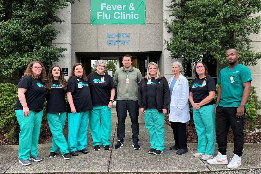 Staff members of the Huntsville Hospital Fever & Flu Clinic stand in front of the clinic on the last day of business
