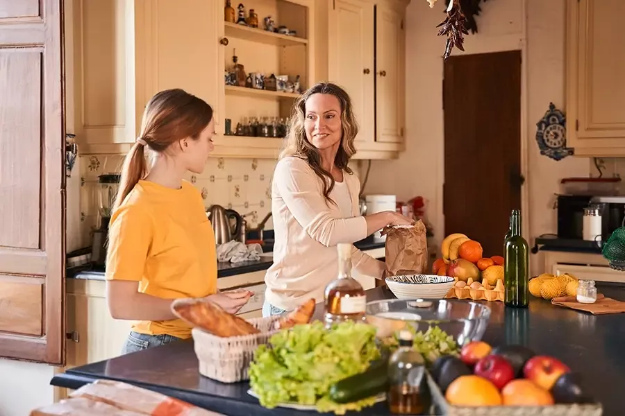 Mom and daughter at a kitchen island food prepping