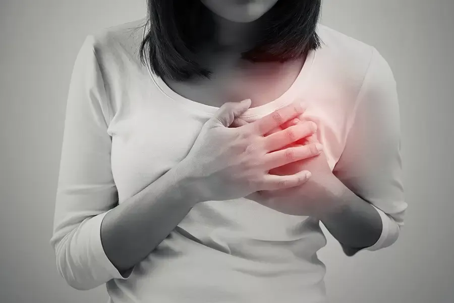 Woman holding her chest near her heart