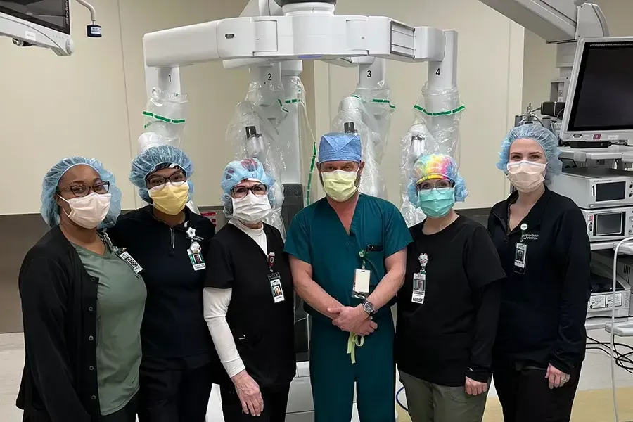 Madison Hospital robotic surgery team members stand in a robotic surgical suite.